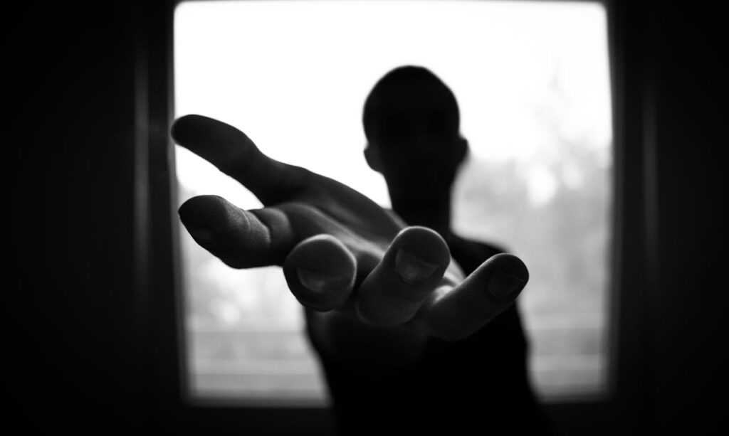 Black and white image of a person offering a helping hand, symbolizing support during depression